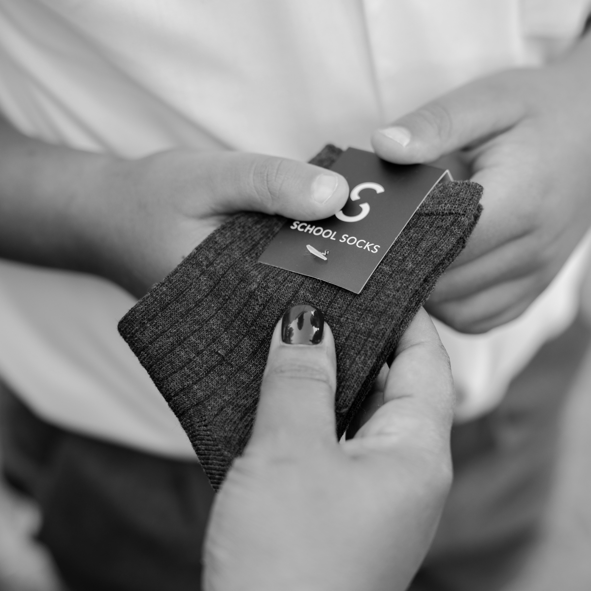 A learner being handed a pair of school socks